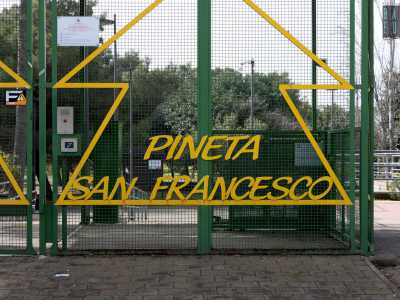...varcando l�ingresso protetto da una cancellata che riporta il nome del parco e il disegno di alberi stilizzati